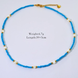 Detail of beaded necklace with blue stones, white pearls, and gold lobster clasp closure