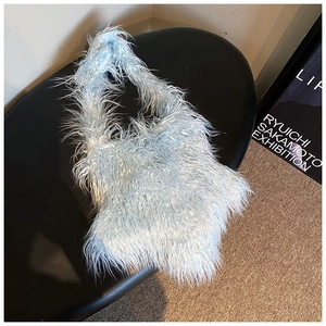 Detail of light blue fluffy faux fur tote bag with soft plush texture on black surface