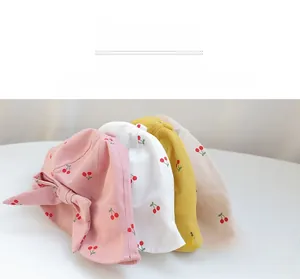 Set of four cotton baby sun hats in pink, white, yellow, and beige with cherry prints