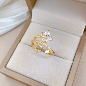Adjustable gold clover ring with sparkling zircon stones in a jewelry box, 45-degree view