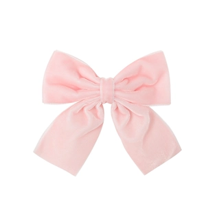 Close-up of pink velvet bow hair clip showing soft fabric texture and elegant detail
