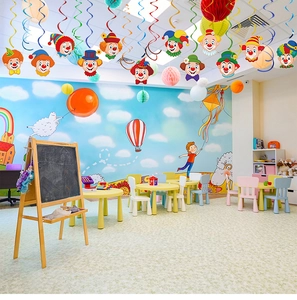 Circus clown hanging decorations with colorful swirls and honeycomb balls on ceiling