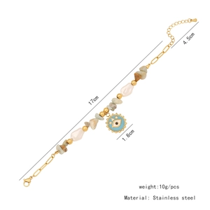 Detail of beaded gold bracelet with natural stone pearls and blue evil eye charm