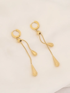 Detailed view of long gold teardrop earrings with snake chains and smooth metal pendants