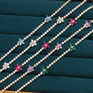 Close-up of colorful flower charm necklaces with micro-set zircons on green velvet
