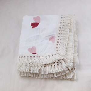 Detail of double-layer cotton baby blanket with red heart prints and tassel lace edges
