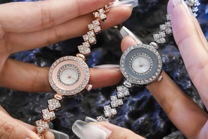 Detailed macro view of diamond-encrusted women's bracelet watches in rose gold and silver