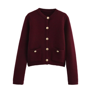 Detailed view of burgundy knit cardigan featuring gold buttons and ribbed cuffs