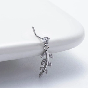 Macro shot of silver L-shaped nose stud with leaf zircon dangle in stainless steel