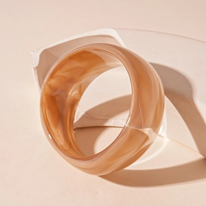 Detail of amber marble acrylic wide cuff bracelet with smooth polished resin texture