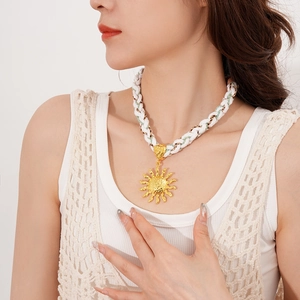 Detail of bohemian sun pendant necklace with three-color hand-woven cord and hammered texture