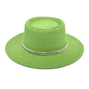 Macro shot of green straw hat with silver chain detail and textured woven finish