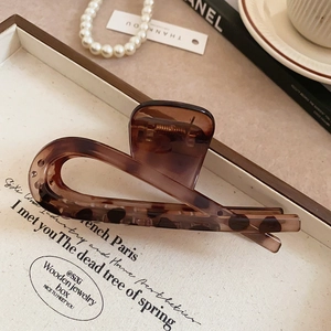 Detail of cross-shaped tortoiseshell hair claw clip in acrylic with metal spring
