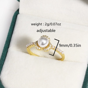 Macro shot of an adjustable golden pearl cluster ring with zircon petals in a jewelry box