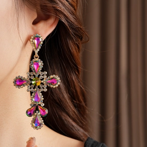 Close-up of vintage baroque cross earrings with colorful rhinestones on a model