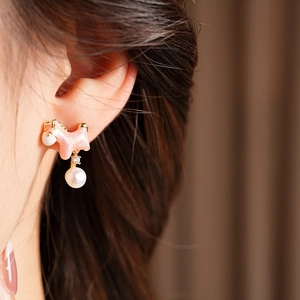 Detailed view of pink puppy stud earring with 18K gold plating and a white round pearl
