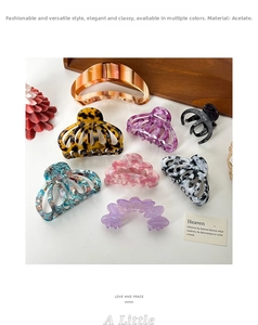 Flat lay of acetate hair claws in leopard, tortoiseshell, and lavender patterns on white desk