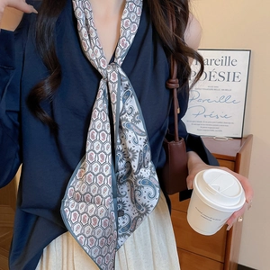 Close-up of paisley print silk neck scarf necklace on model in elegant indoor setting