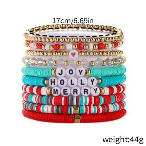 Stacked Christmas beaded bracelets featuring festive red green colors and Joy Merry charms