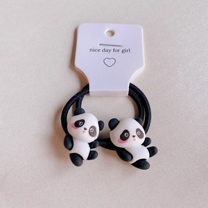 Nahaufnahme eines Paares niedlicher Panda-Haargummis auf einer weißen Karte mit Gummibändern