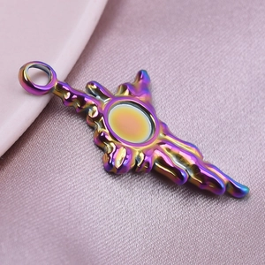Macro shot of iridescent rainbow stainless steel wing pendant on pink silk fabric