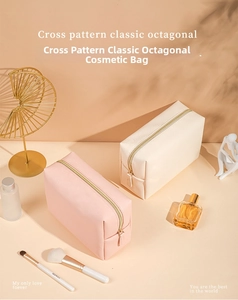 Detail of octagonal makeup bags in pink and beige cross-grain leather with gold zippers