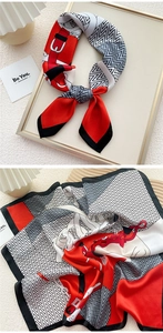 Detail of silk-feel scarf with vintage belt buckle pattern and geometric waves in red and white