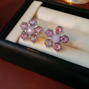 Élégantes boucles d'oreilles fleurs mauves en cristal sur boîte à bijoux de luxe