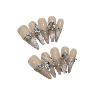 Faux ongles faits main en amande longue avec dégradé pailleté argent et strass étoiles