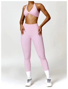 Detailed view of pink crossover sports bra and high-waisted yoga leggings workout set