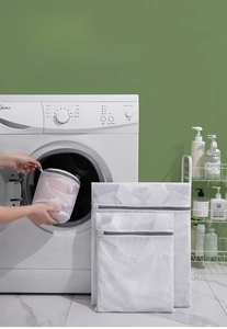 Close-up of durable white mesh laundry bags with grey zippers for delicate clothes
