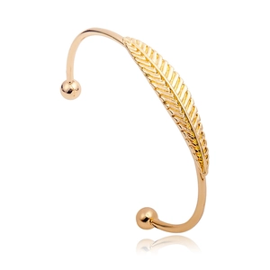 Elegante brazalete abierto de oro con diseño de pluma detallado sobre fondo blanco