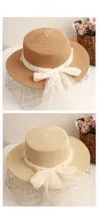 Detail of flat top straw hat with lace mesh ribbon, pearls and large decorative bow knot