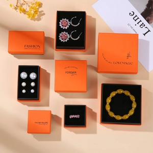 Flat lay of premium orange jewelry drawer boxes with elegant floral earrings and necklace