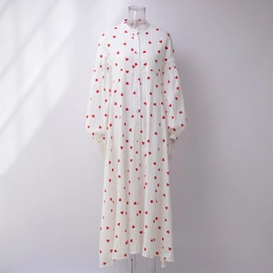 Détail d'une robe en coton blanc à imprimé cœurs rouges et manches lanternes