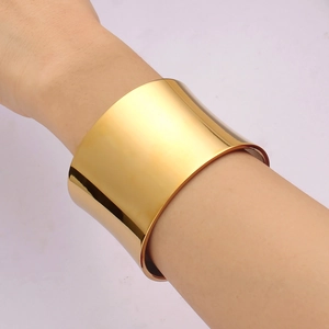 Polished 18K gold titanium steel wide cuff bangle shown on wrist with mirror finish