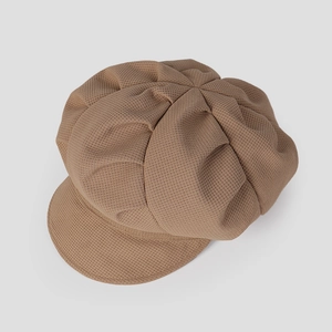 Vue détaillée de la texture gaufrée camel foncé et des coutures d'une casquette gavroche