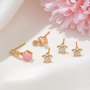 Close-up of gold-plated flower and heart earring set with pink and white zirconia stones