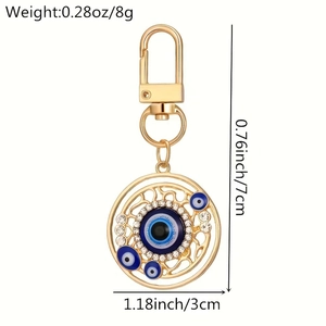 Detail of evil eye keychain with heart charms, gold alloy plating and blue rhinestones
