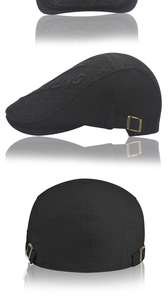 Detail of black beret cap featuring gold metal buckle and quilted diamond stitching
