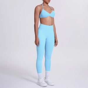 Dettaglio del set yoga azzurro con pantaloni a vita alta e reggiseno sportivo allacciato