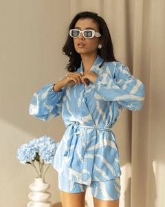 Detail of light blue printed pajama set with tie-waist top and matching shorts on model
