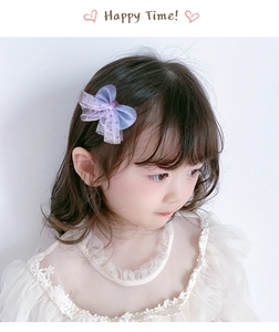 Detail of a purple gradient mesh bow hair clip with sequins worn by a young girl
