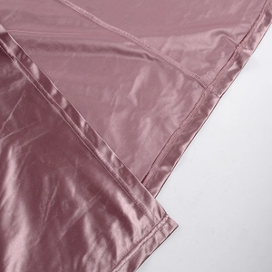 Close-up of smooth rose pink satin fabric with high-quality stitching and mesh lining