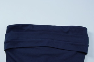 Détail de la robe bustier bleu foncé montrant le design plissé et le tissu lisse stretch
