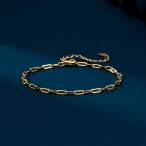 Close-up of golden s925 silver paperclip chain bracelet with lobster clasp and extender