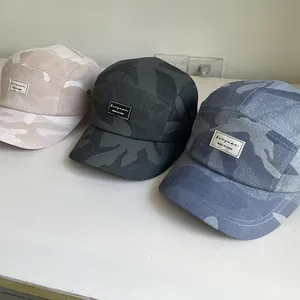 Detailed view of three 5-panel camouflage camp caps in pink, charcoal, and grey blue
