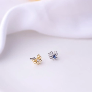 Detailed view of butterfly nose studs with colorful zircon stones in gold and silver finishes