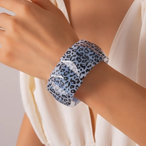 Close-up of wide acrylic leopard print bracelet in sky blue on a woman's wrist