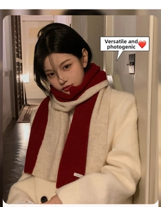 Detail of red and white color-block knitted scarf paired with a stylish long white coat